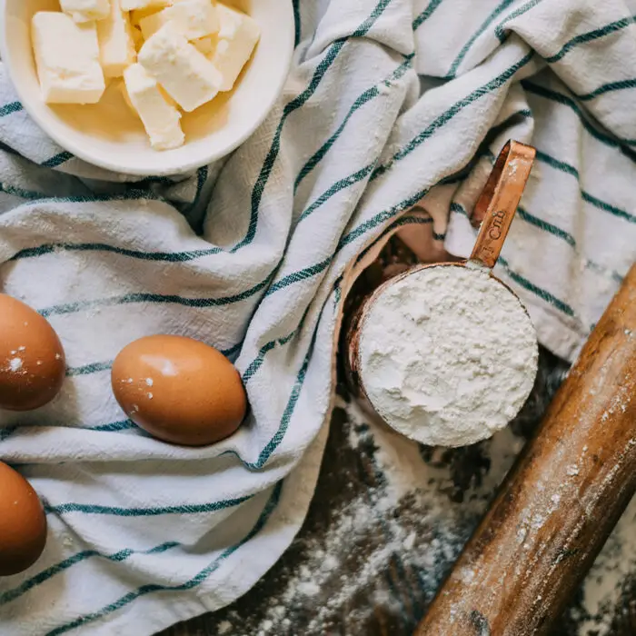 Flour, eggs, butter with a rolling pin and a cloth